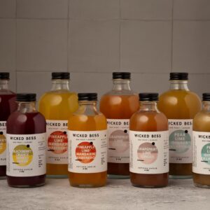 Wicked Bess artisan shrubs in both bottle sizes — Blackberry Orange Mango Ginger, Pineapple Lime Mandarin Habanero, Grapefruit Lime Ginger and Pear Lime Ginger Jalapeño