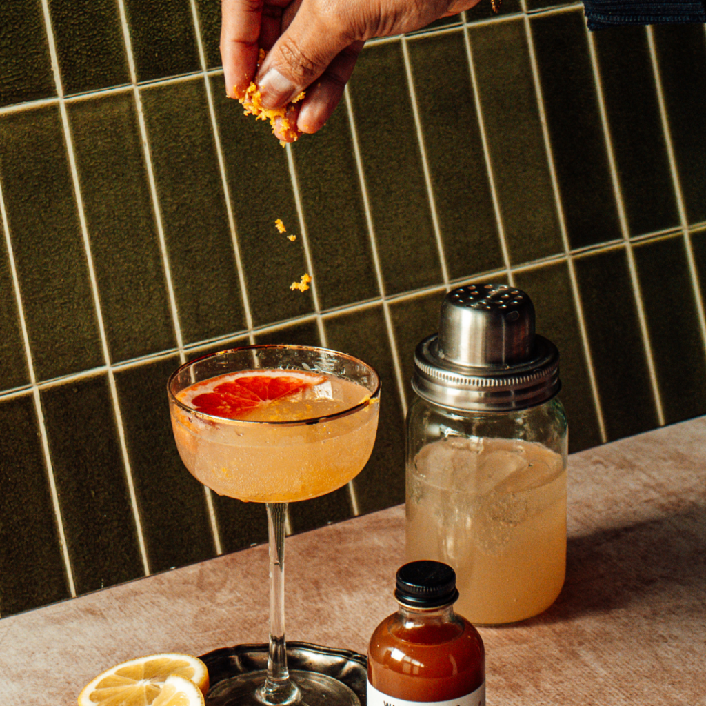 Lady Ella cocktail with a bottle of Wicked Bess shrub