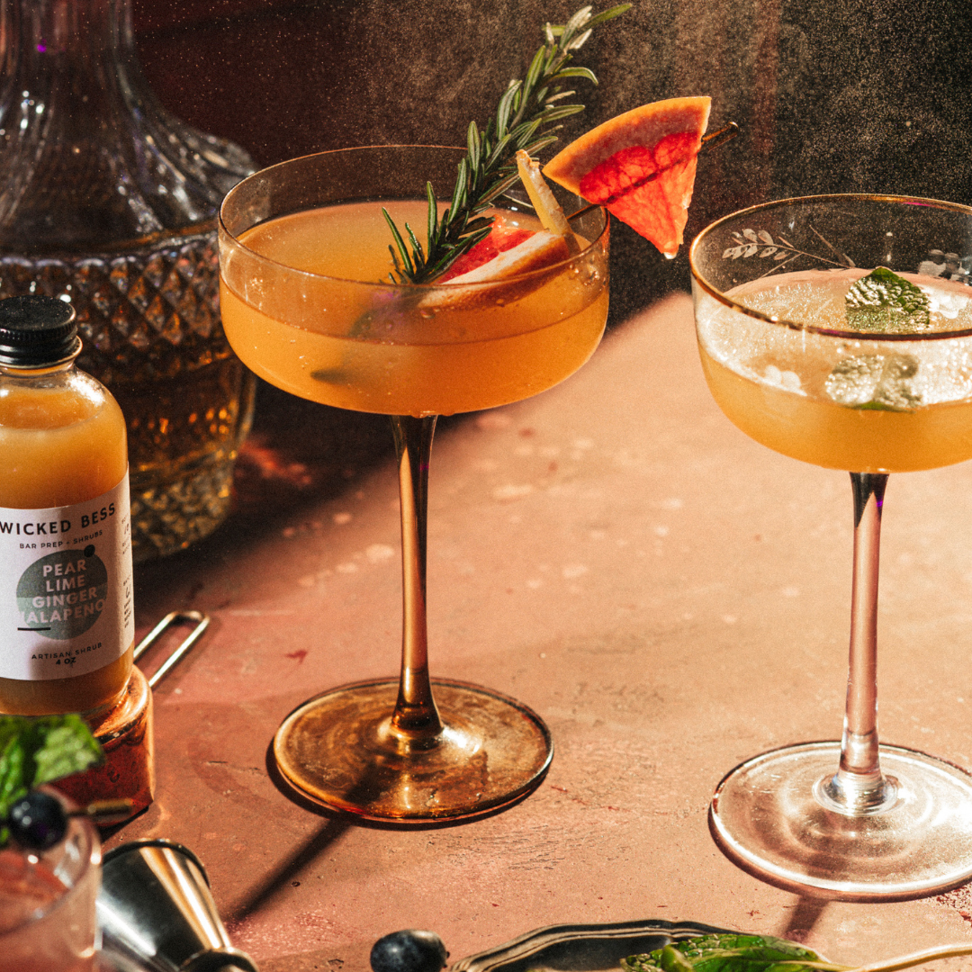 A Clear High Note cocktail with a bottle of Wicked Bess shrub