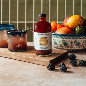 Phenomenal Woman cocktail with a bottle of Wicked Bess shrub