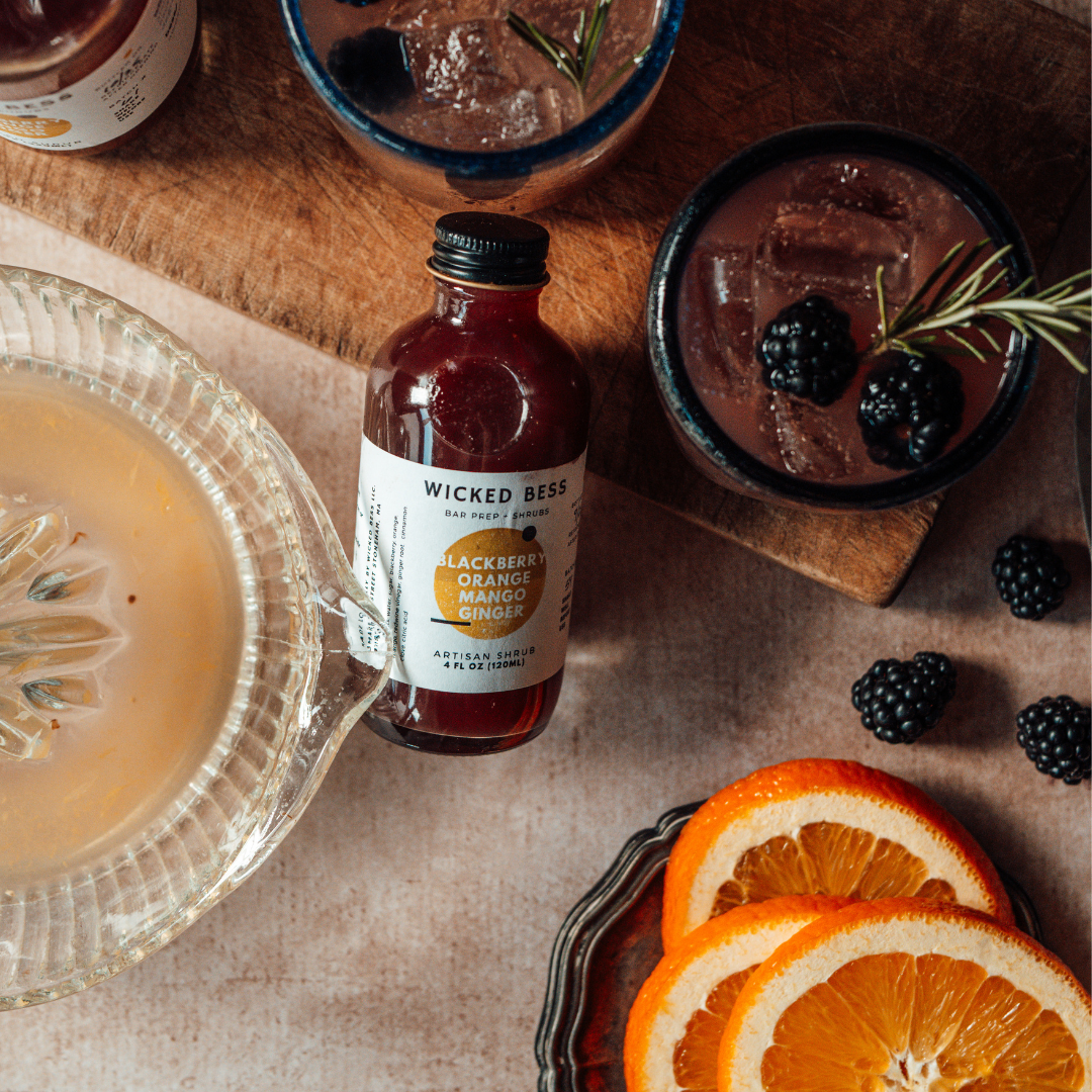 Caged Bird's Song cocktail with a bottle of Wicked Bess shrub
